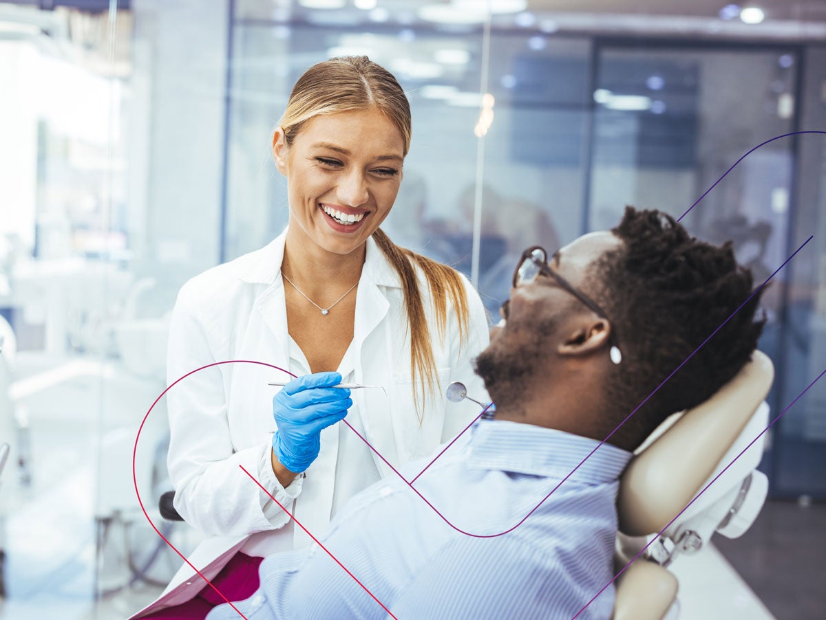 Smiling dentist performing a dental exam with a patient