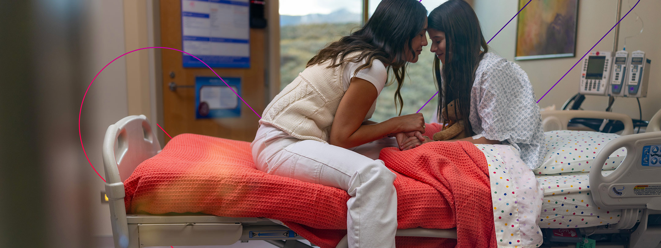 Mother and daughter sitting on hospital bed