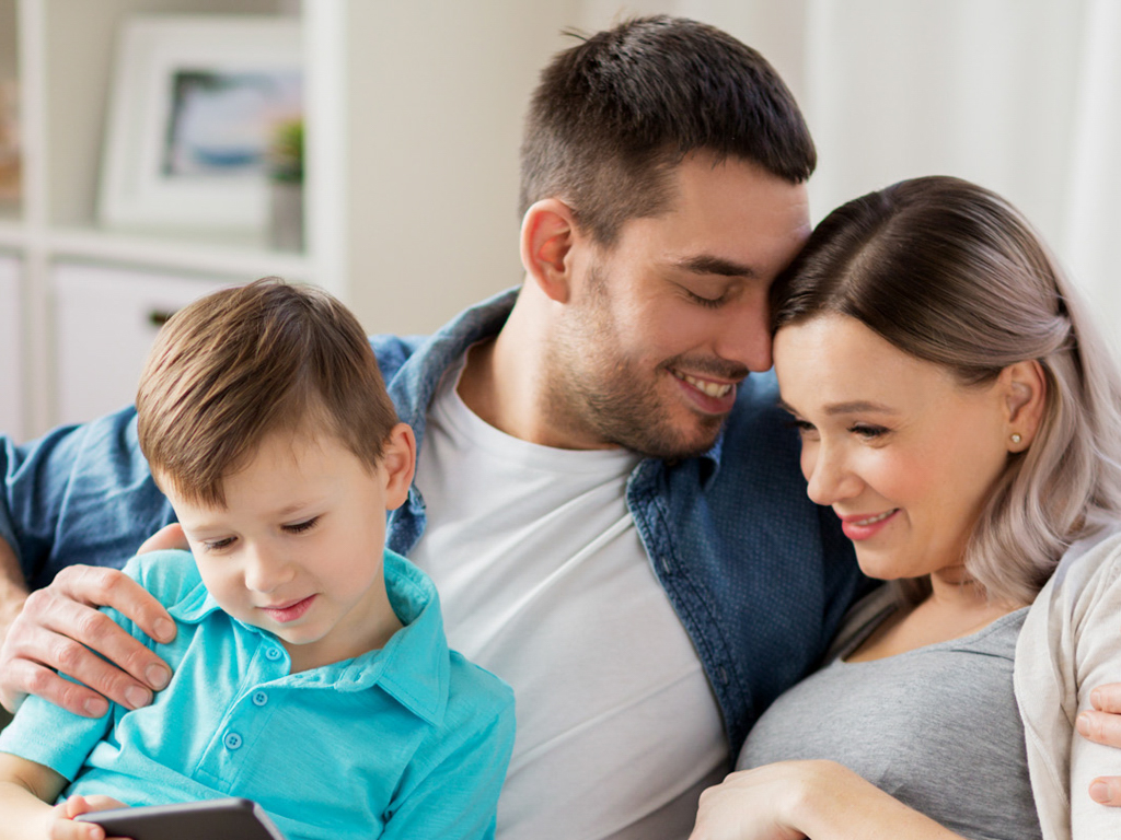 A husband and wife sitting together with their son on their laps
