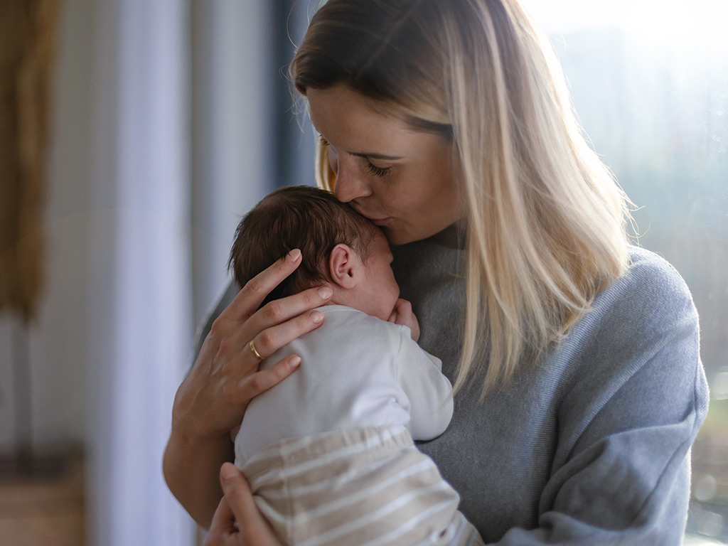 A mother holds her newborn baby.