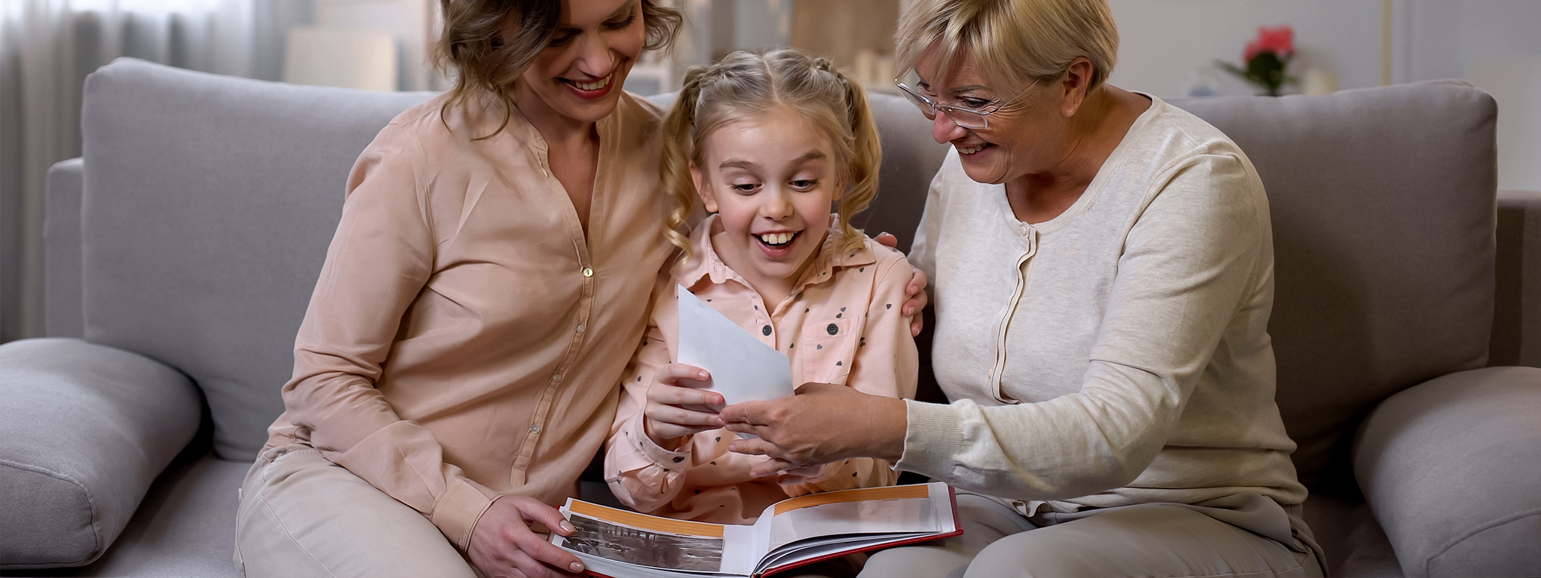 A mother, daughter, and grandmother look at old photos together