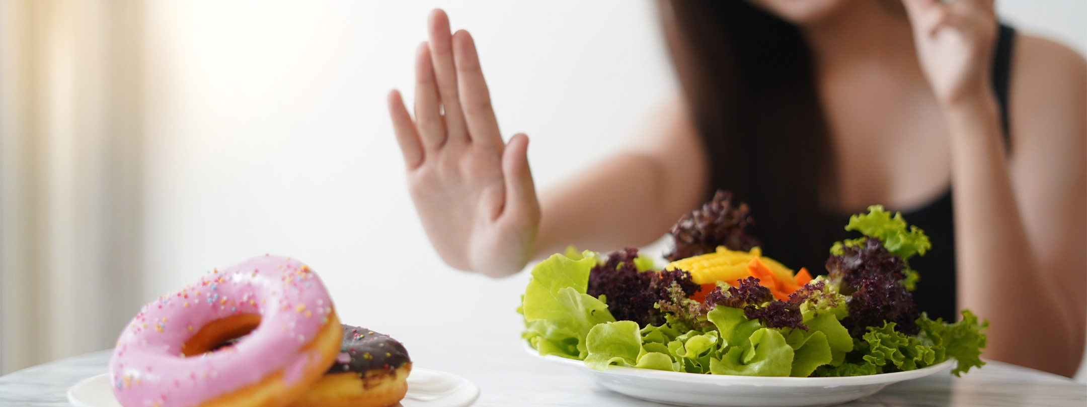 Woman refuses donuts and chooses salad instead
