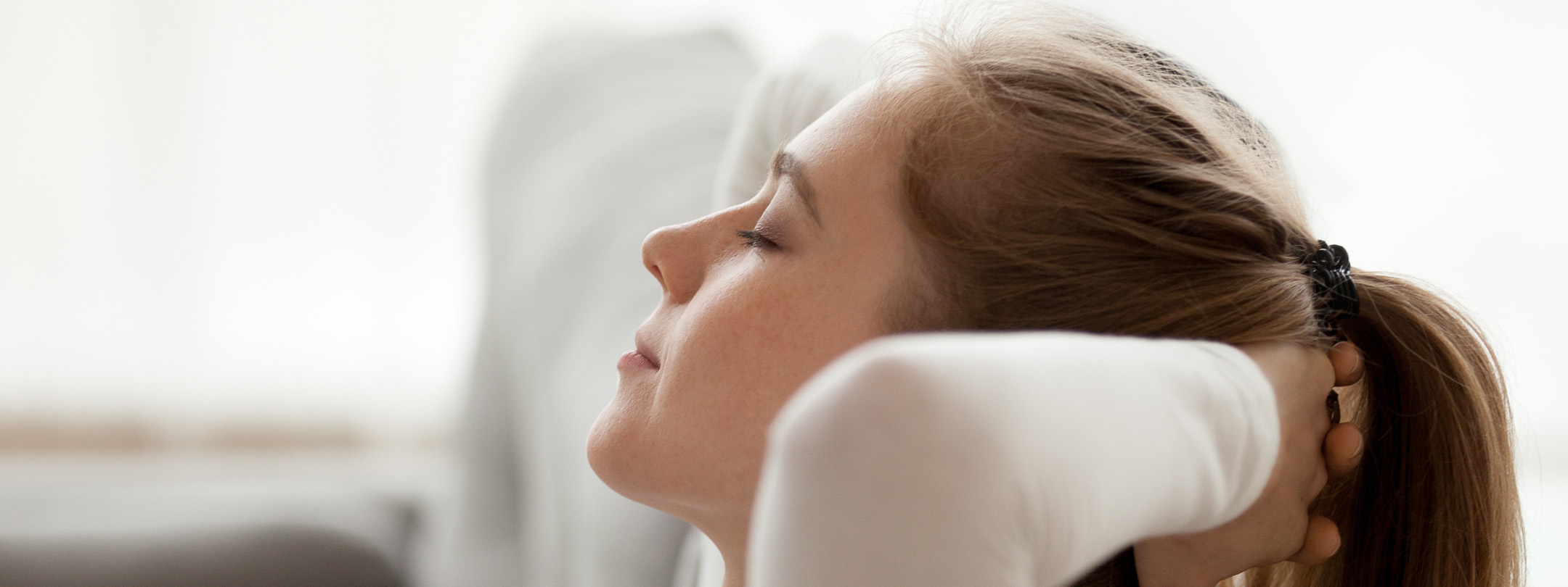 A young woman relaxes at home with her eyes closed