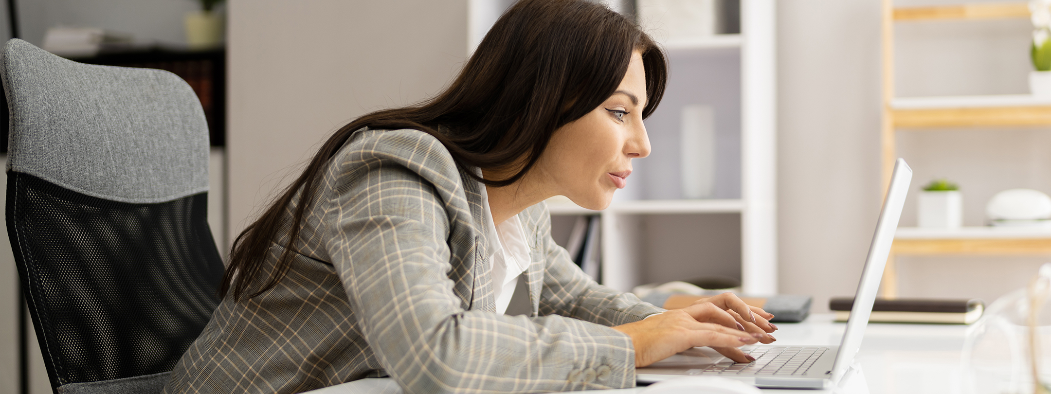 woman hunched over looking at her computer screen