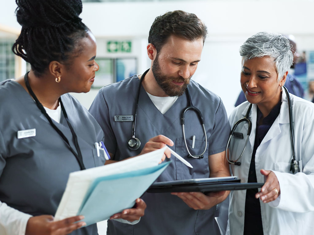 Group of medical providers looking at a tablet screen