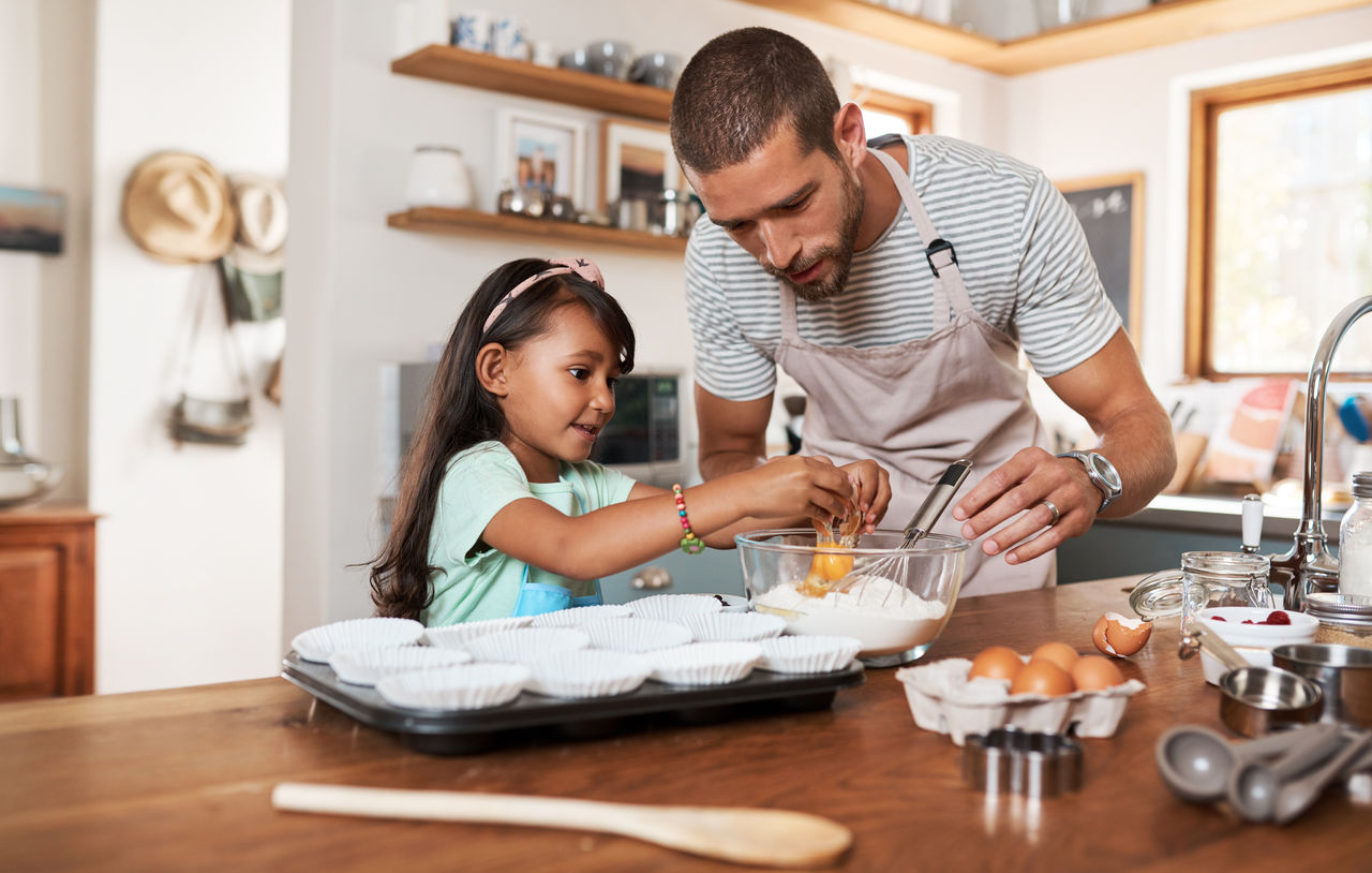 Cropped shot of a young man baking at home with his young daughter
